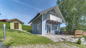 A two-story house with a stone-paved driveway and a wooden deck. - Siglanów by Interhome (Wisla)
