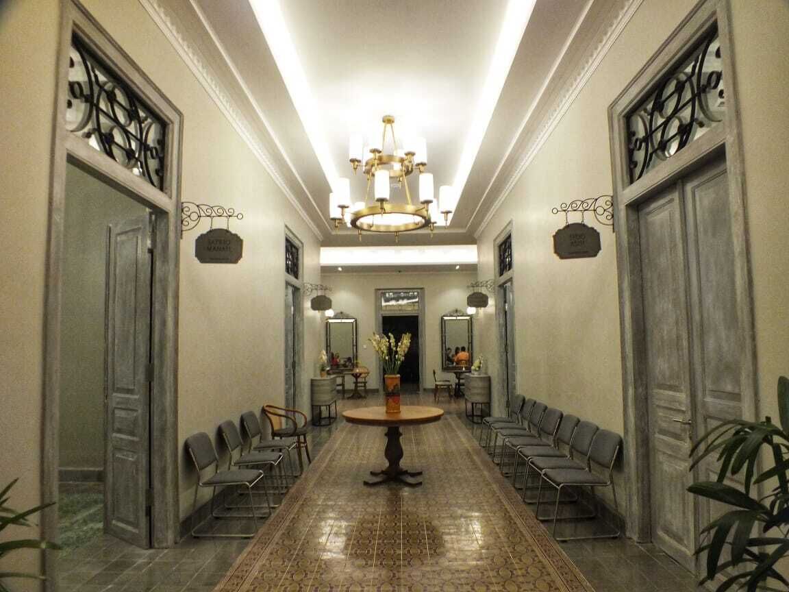 Een hotel lobby met een lange receptiebalie, stoelen en een kroonluchter.