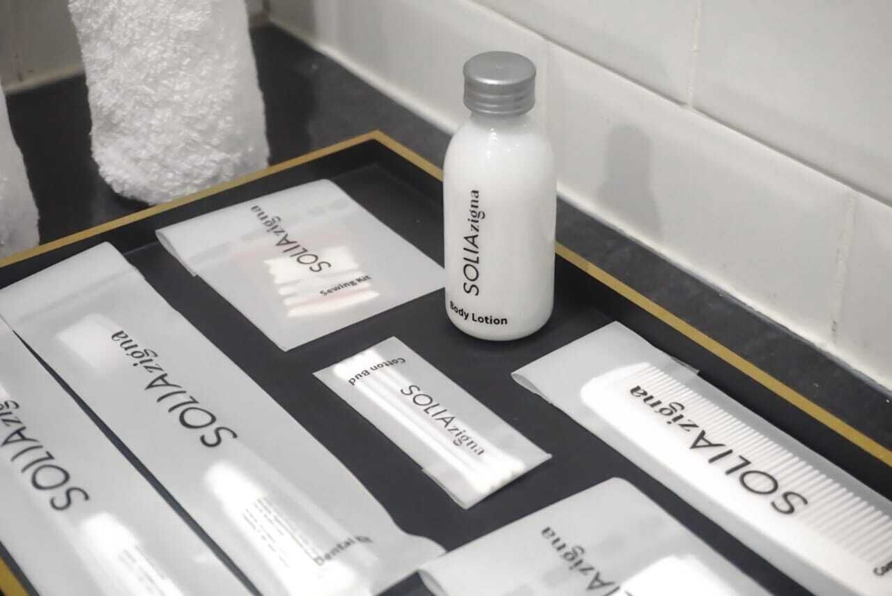 A tray with various toiletries including a bottle of body lotion and several labeled containers.