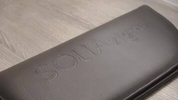 Un estuche de cuero gris con texto en relieve.