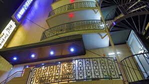 Un edificio de varios niveles con una escalera en espiral y barandales de metal ornamentados.