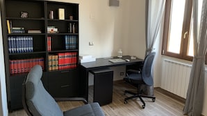 A study room with a desk, chair, bookshelf, and a window with curtains. - Alloggio Turistico Belvedere Gallese (Gallese)