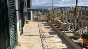 A balcony with potted plants, an air conditioning unit, and a view of distant mountains. - Alloggio Turistico Belvedere Gallese (Gallese)