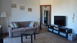 A modern living room with a sofa, TV, and entertainment unit. - Alloggio Turistico Belvedere Gallese (Gallese)