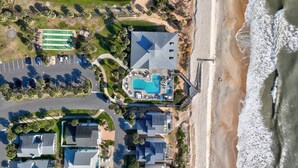 Vista aérea de una propiedad costera con piscina, acceso a la playa y zona de estacionamiento.