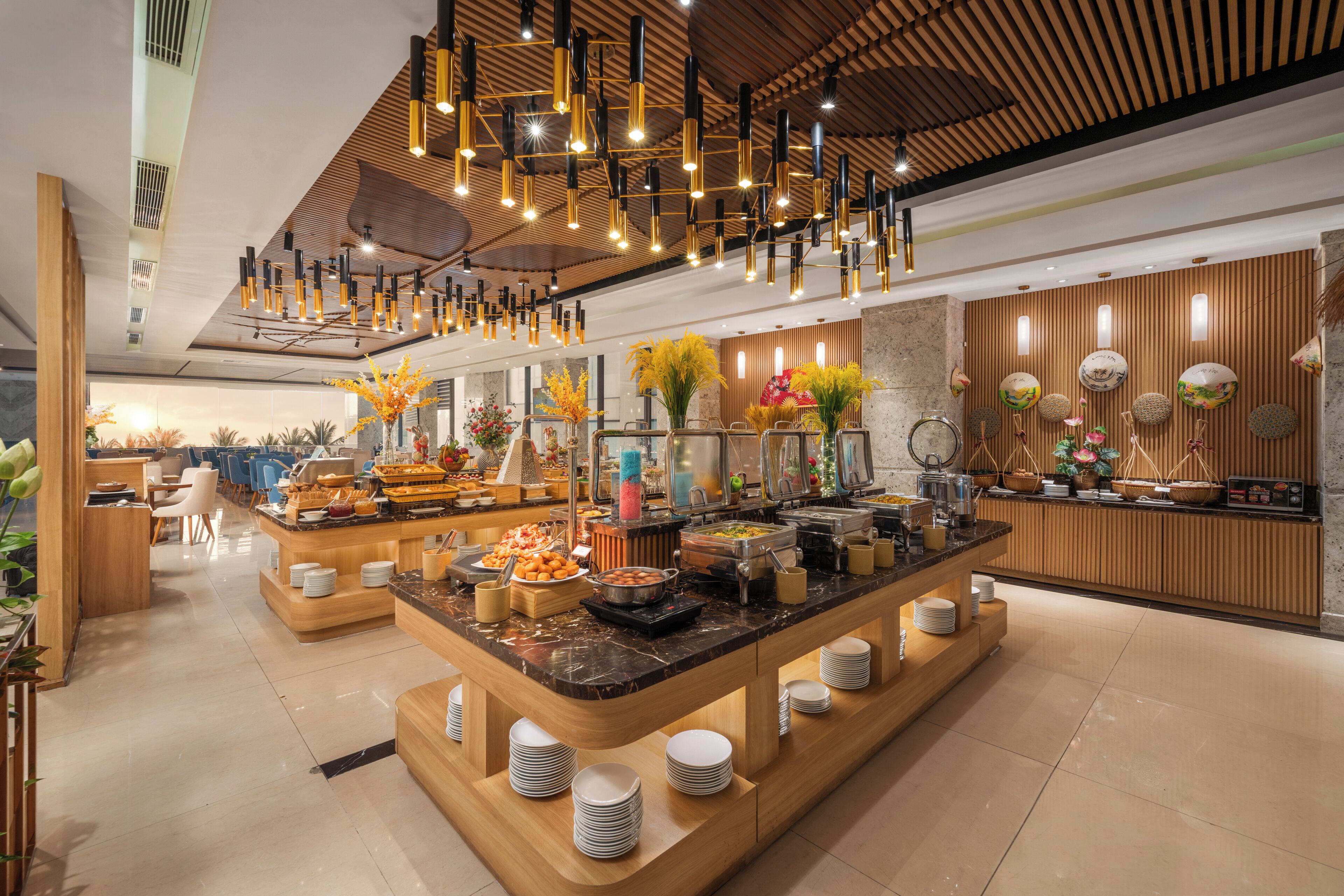 Um lobby de hotel moderno com área de buffet central, detalhes em madeira e luminárias contemporâneas.