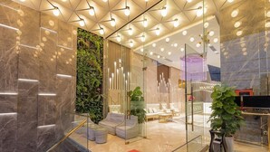 A modern lobby with marble walls, a reception desk, and a seating area with sofas and a coffee table. - Masova Hotel (Nha Trang)