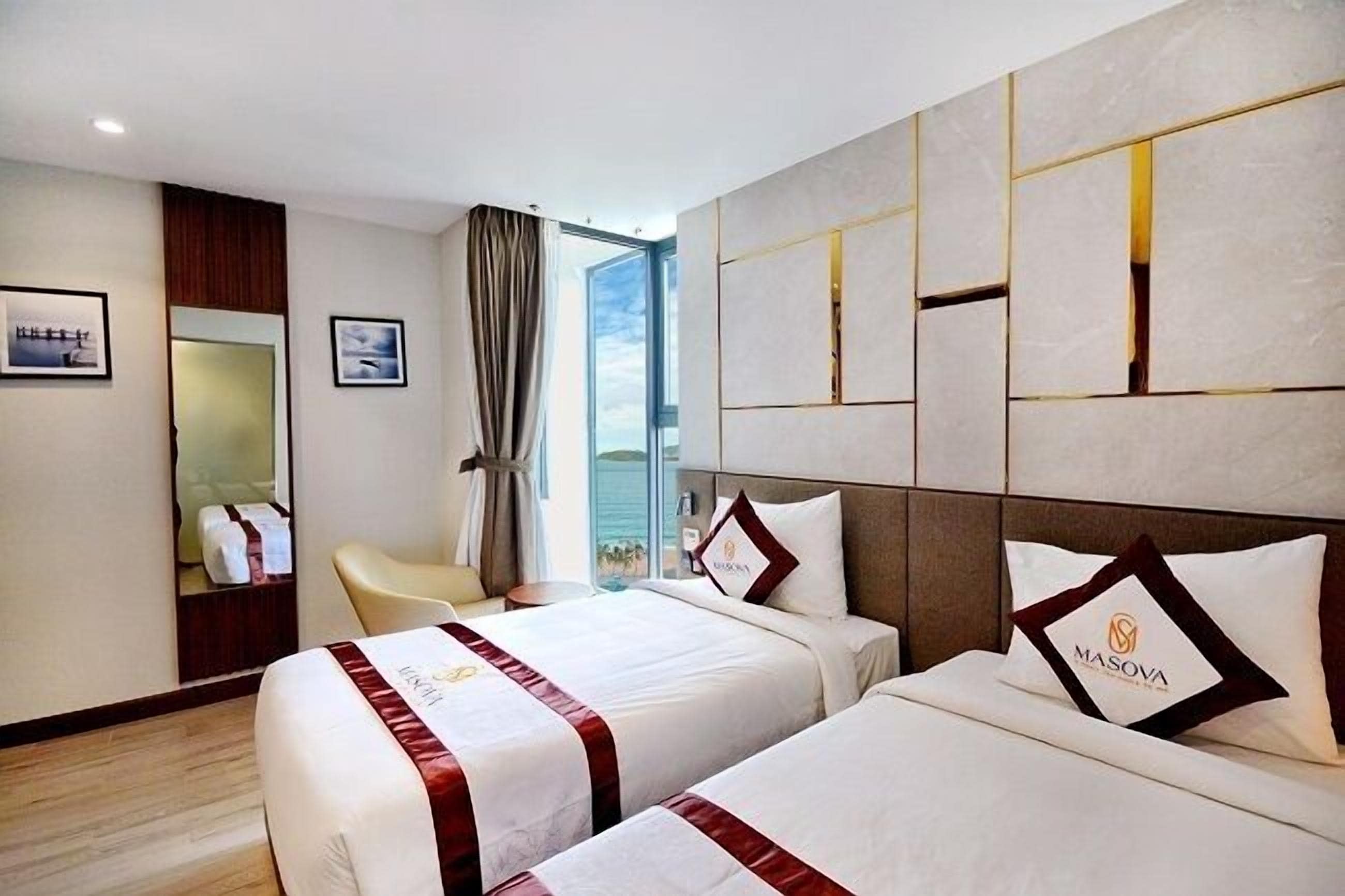 A hotel room with two beds, a large window, a mirror, and a view of the city.