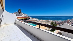 Ein Balkon mit Meerblick und Pool.