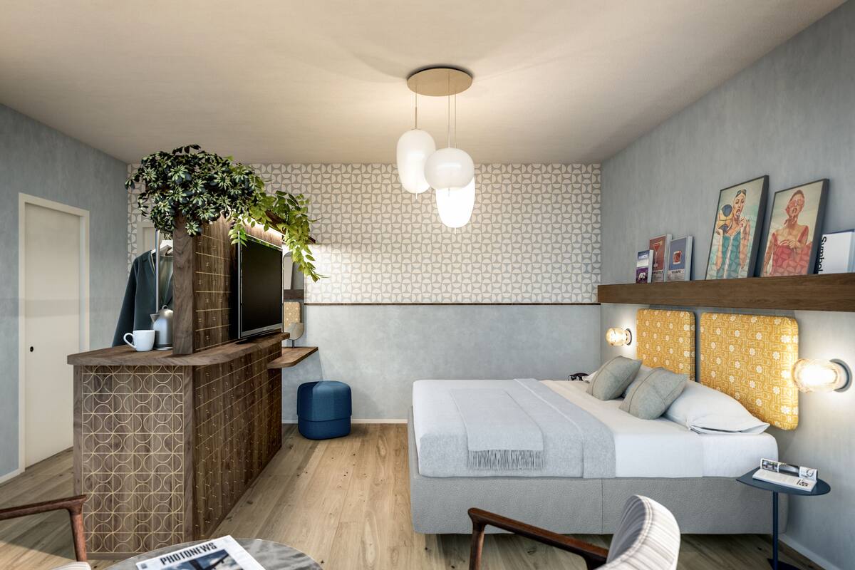A modern bedroom with a bed, bedside table, and a small seating area.