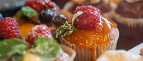 A variety of desserts, including cupcakes and pastries, arranged on a table.