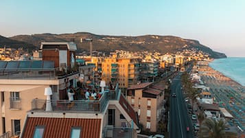 Una cittadina costiera con una spiaggia, edifici con balconi e una strada che conduce alla spiaggia.