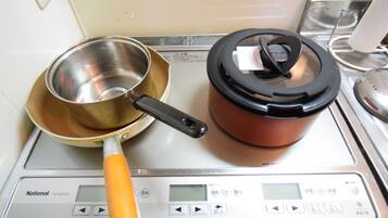 A kitchen scale with a frying pan and a pot on it.