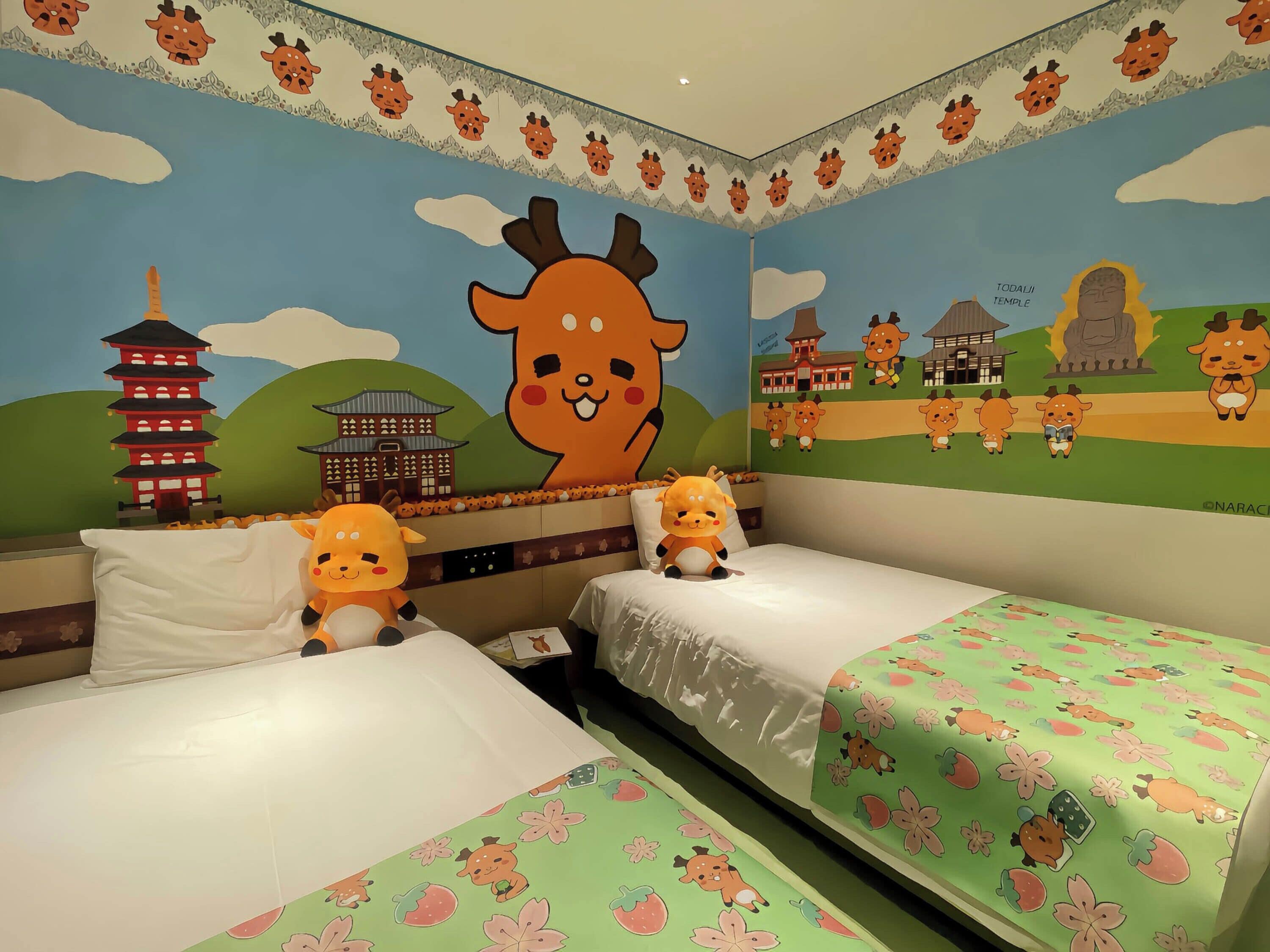A room with two beds, a mural with a large giraffe and Japanese-style buildings, and a decorative border.