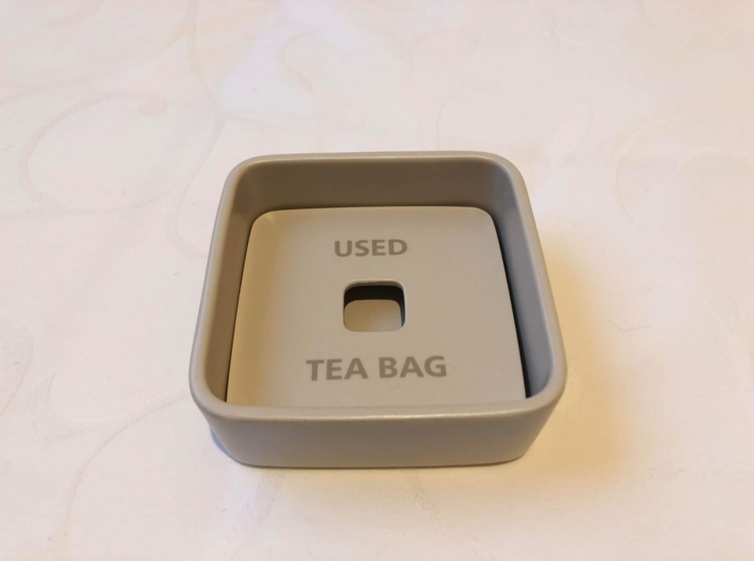 A gray tea bag holder with the words "USED" and "TEA BAG" on it.