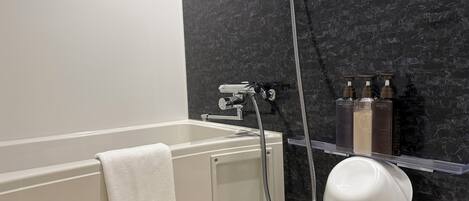 Un baño moderno con bañera, ducha y tocador con artículos de aseo.