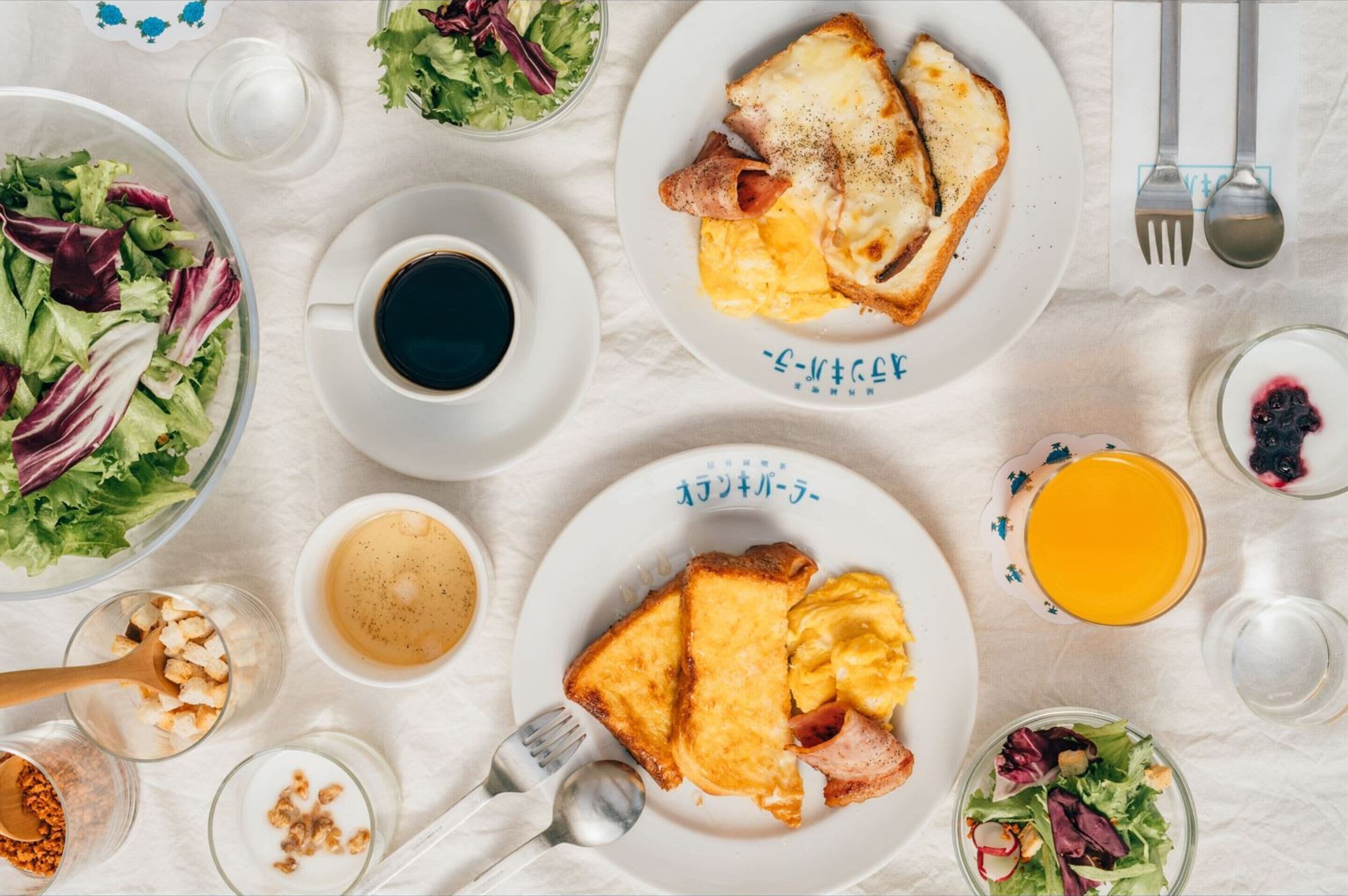 A breakfast setting with various dishes including toast, scrambled eggs, and a salad.