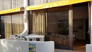 A hotel room with a sliding glass door, a small balcony with a table and chairs, and a view of the interior. - Albufeira, 5 minutes to the beach (42) (Albufeira)