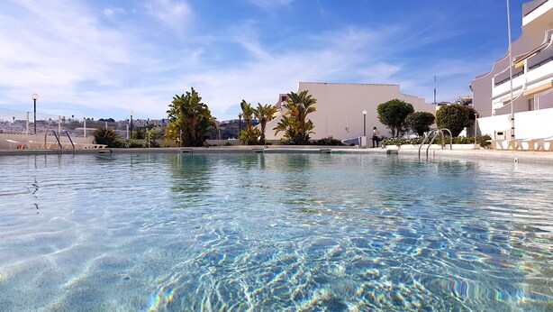 A clear swimming pool with a view of a cityscape in the background. - Albufeira, 5 minutes to the beach (42) (Albufeira)