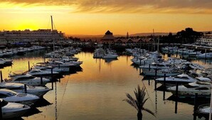 Un port de plaisance rempli de bateaux au coucher du soleil.
