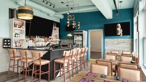 A bar area with stools, a counter, and a neon sign. - Best Western Premier Executive Residency Medicine Hat (Medicine Hat)