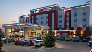 A hotel with a modern facade, multiple parking spaces, and a well-lit entrance. - Best Western Premier Executive Residency Medicine Hat (Medicine Hat)