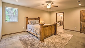 A bedroom with a wooden bed, a ceiling fan, and a large window. - Secluded Home w/ Gas Grill, 3 Mi to Boating! (Yantis)