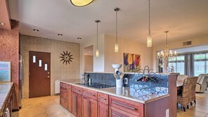 Una cocina moderna con una isla central, armarios de madera e iluminación colgante.
