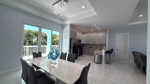 A modern kitchen with white cabinets, a stainless steel refrigerator, and a microwave. - Blue Paradise 5bed/5bath walking distance to the beach with a private pool (Marathon)