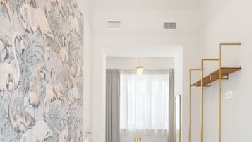 Un dormitorio con una cama grande, un baño con bañera y una pared con papel tapiz floral.