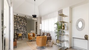 A spacious living room with a modern sofa, a dining area with a table and chairs, and a decorative plant. - Be Mate Málaga Centro (Málaga)