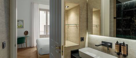 A modern bathroom with a large mirror, a freestanding bathtub, and a sleek vanity.