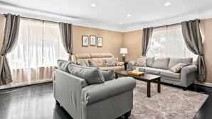 A modern living room with two sofas, a coffee table, and a lamp.