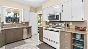 A kitchen with white cabinets, a microwave, stove, and a dishwasher.