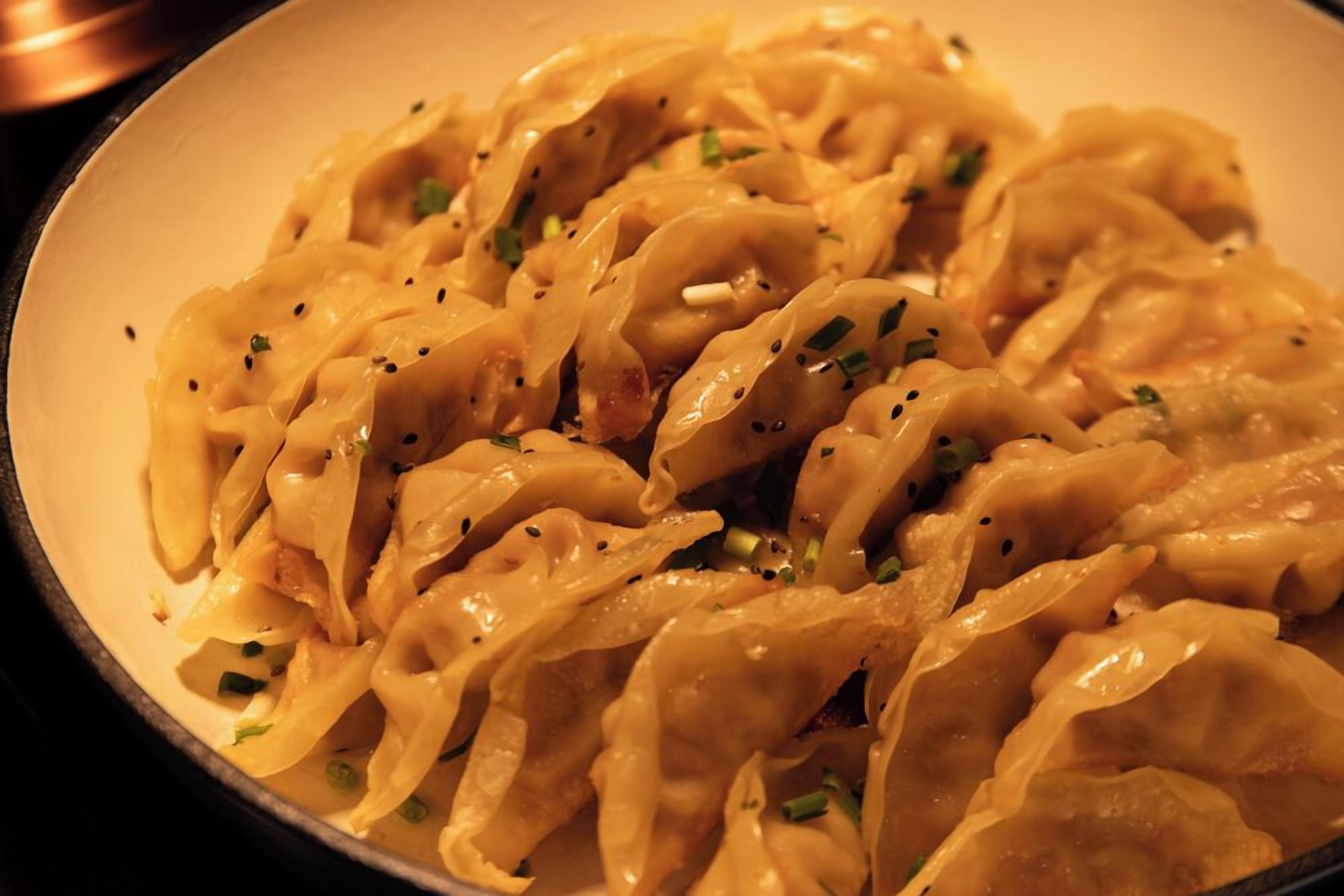 A plate of dumplings garnished with herbs.