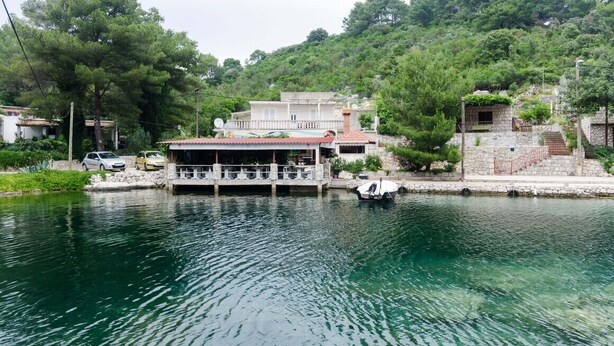 Propiedad frente al agua con una casa, muelle y un barco.