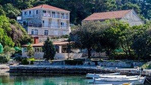 A coastal building with a stone facade, a red-tiled roof, and a balcony. - Mljet Pearl in Pomena,National Park Mljet (Mljet)