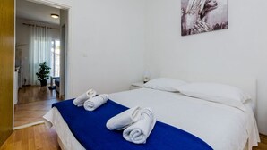 A hotel room with a bed, a painting, and a bathroom visible through an open door. - Mljet Pearl in Pomena,National Park Mljet (Mljet)