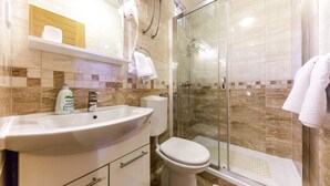 A bathroom with a sink, toilet, and glass shower enclosure. - Charming studio with garden terrace (Dubrovnik)
