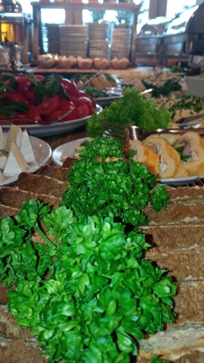 Un bufé con diferentes opciones de comida, incluyendo pan, ensaladas y verduras.