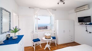A bedroom with a large window, white wardrobe, and a television on a shelf. - apt Dubrovnik,sea view,near Old tow (Dubrovnik)