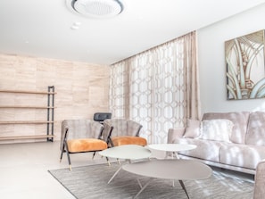 Relax in this stylish living space with a sofa, armchairs, and a coffee table.