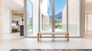 Ein modernes Interieur mit einer großen Schiebeglastür, die auf einen Balkon mit Bergblick führt.