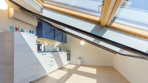 Eine moderne Küche mit Oberlicht, weißen Schränken und einer Arbeitsplatte mit Kaffeemaschine.