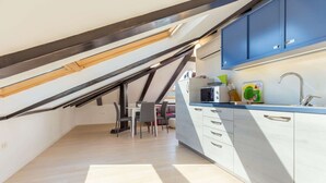 Eine moderne Küche mit weißen Schränken, einer blauen Arbeitsplatte und einer eingebauten Mikrowelle.