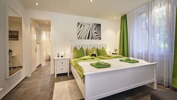Relax in a serene bedroom with a large bed, bedside table, and zebra-themed artwork.