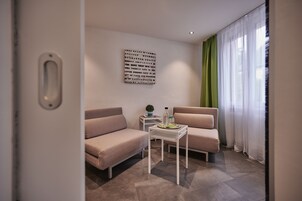Suite Deluxe, 2 habitaciones | Zona de estar | Televisión de pantalla plana de 30 cm con canales por satélite
