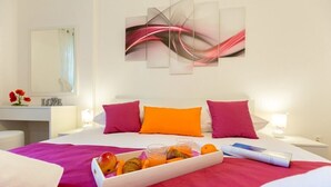 Ein Hotelzimmer mit Bett, Frühstücksbrett, Spiegel und einem Wandbild.