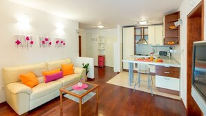 Ein modernes Apartment mit Wohnzimmer, Küche und Essbereich.