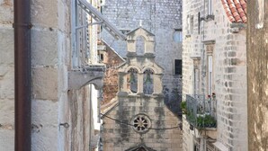 A narrow street with historic stone buildings, a bell tower, and a wrought iron balcony. - STUDIO INN - heart of the city! (Dubrovnik)